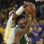 
              Boston Celtics guard Marcus Smart, bottom, shoots against Golden State Warriors center Kevon Looney during the second half of Game 1 of basketball's NBA Finals in San Francisco, Sunday, June 5, 2022. (AP Photo/Jed Jacobsohn)
            