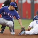 
              Texas Rangers shortstop Corey Seager, left, is late with the tag as Kansas City Royals' Whit Merrifield, right, steals second base during the first inning of a baseball game in Kansas City, Mo., Monday, June 27, 2022. (AP Photo/Colin E. Braley)
            