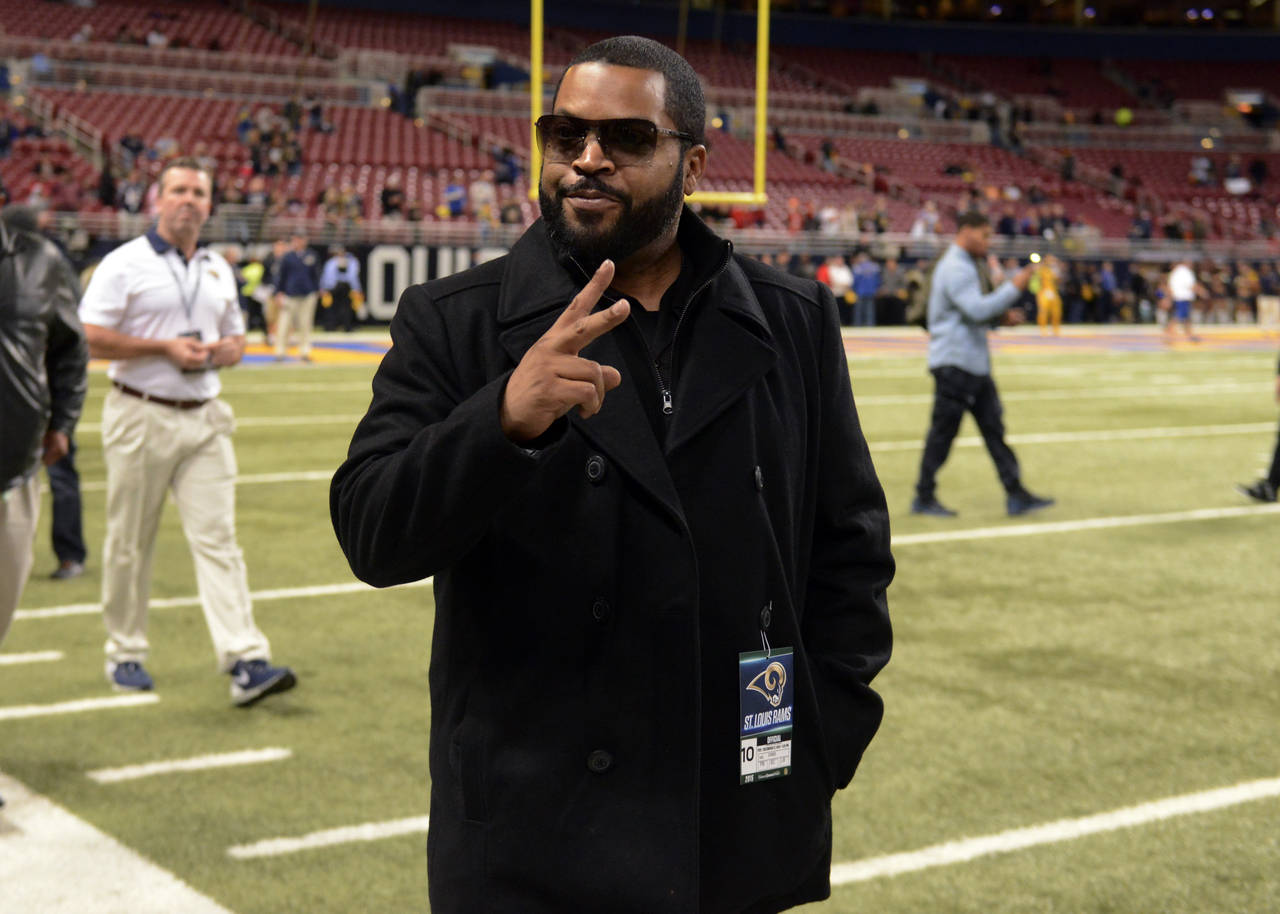 FILE - Entertainer Ice Cube gestures on the sidelines before the start of an NFL football game betw...