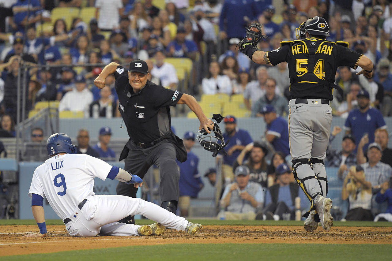 Los Angeles Dodgers' Gavin Lux, left, is called out by home plate umpire Chad Fairchild, center, af...
