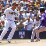 
              San Diego Padres third baseman Manny Machado, left, prepares to tag out Colorado Rockies' Jose Iglesias, right, in the fifth inning of the first game of a baseball doubleheader Saturday June 11, 2022, in San Diego. (AP Photo/Mike McGinnis)
            