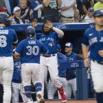 
              Toronto Blue Jays catcher Alejandro Kirk (30) celebrates with Vladimir Guerrero Jr. after scoring against the Boston Red Sox during the second inning of a baseball game Wednesday, June 29, 2022, in Toronto. (Christopher Katsarov/The Canadian Press via AP)
            