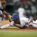 
              Texas Rangers' Ezequiel Duran, right, dives back to first base, beating the pickoff tag by Houston Astros first baseman Yuli Gurriel during the fourth inning of a baseball game in Arlington, Texas, Tuesday, June 14, 2022. (AP Photo/LM Otero)
            