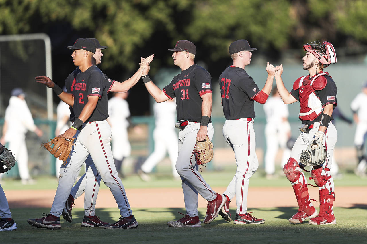 Stanford players celebrate after defeating Connecticut in an NCAA college baseball super regional t...