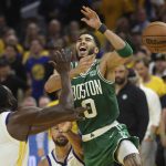 
              Boston Celtics forward Jayson Tatum (0) loses the ball while being defended by Golden State Warriors forward Draymond Green (23) and guard Stephen Curry during the second half of Game 1 of basketball's NBA Finals in San Francisco, Sunday, June 5, 2022. (AP Photo/Jed Jacobsohn)
            