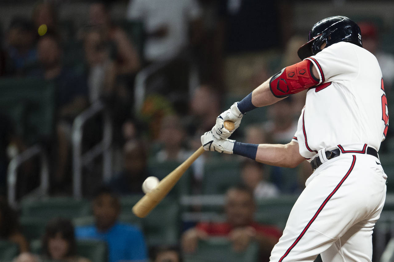 Atlanta Braves Austin Riley hits a tip foul in the eighth inning of a baseball game against the San...