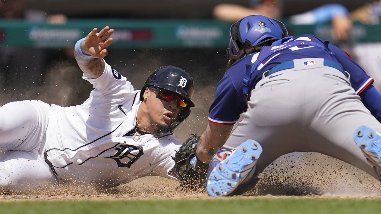 Detroit Tigers' Javier Baez slides safely to score ahead of the tag of Texas Rangers catcher Jonah ...