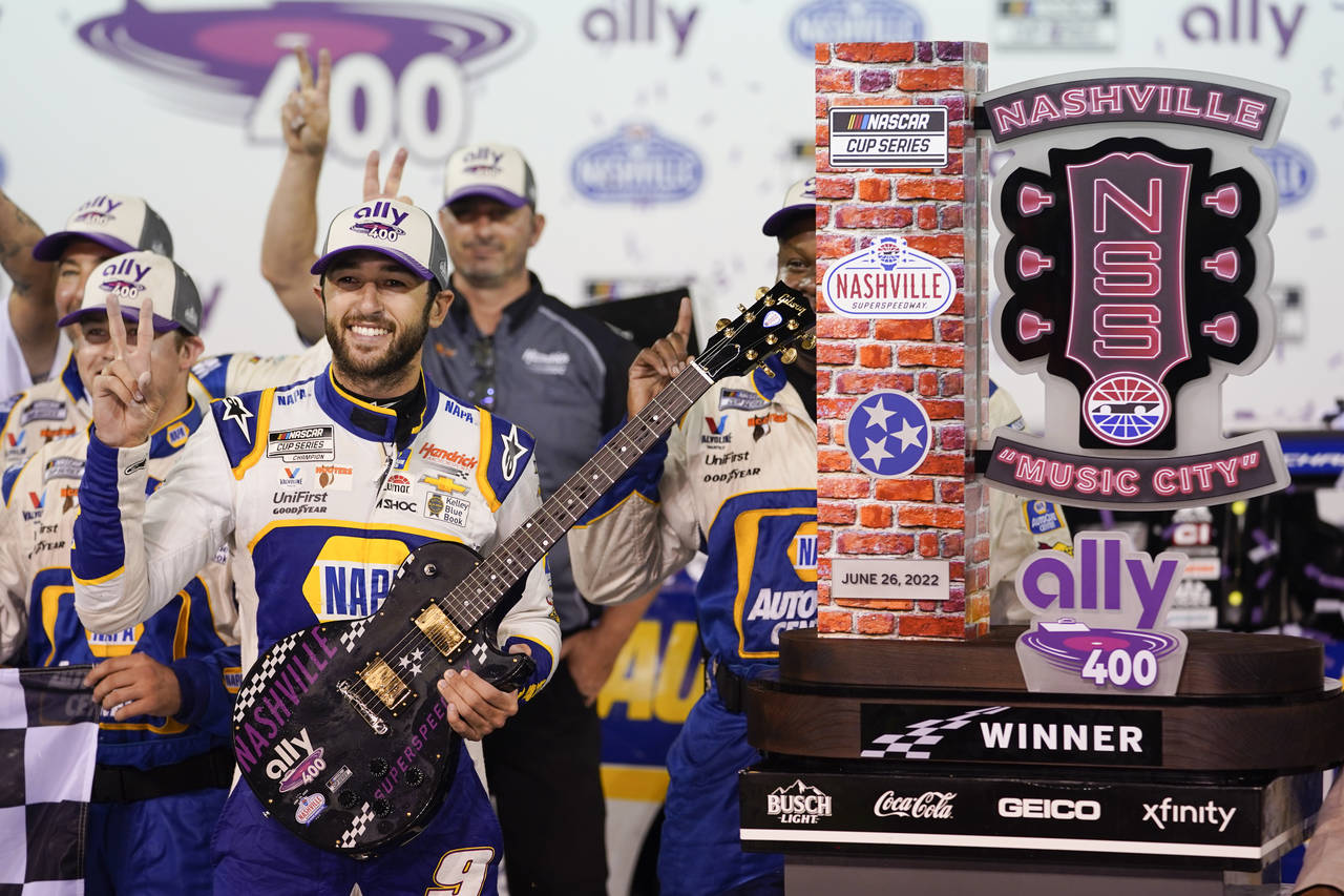 Chase Elliott poses with his guitar and trophy after winning a NASCAR Cup Series auto race Sunday, ...