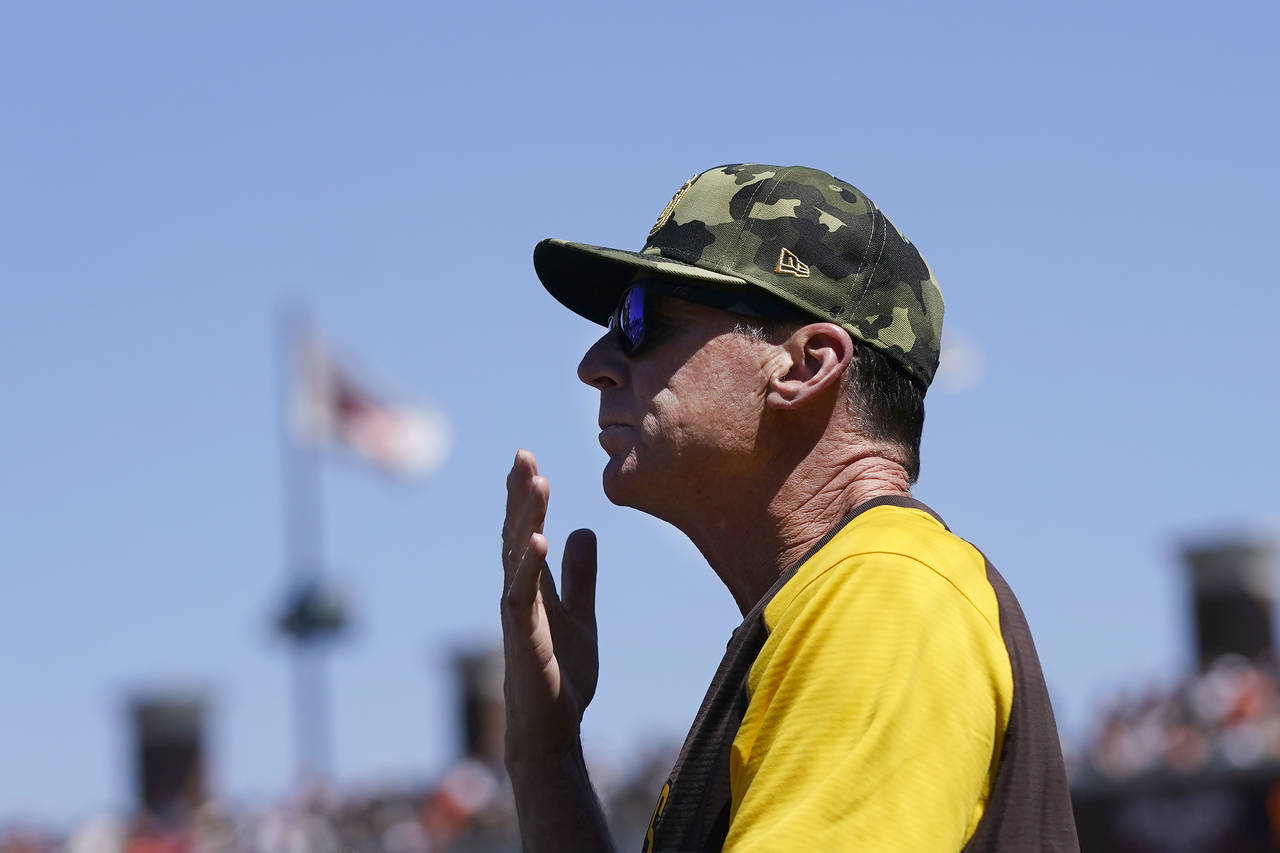 San Diego Padres manager Bob Melvin signals from the dugout during the sixth inning of his team's b...