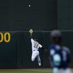 
              Oakland Athletics center fielder Ramon Laureano (22) chases the ball as Seattle Mariners' J.P. Crawford, foreground, runs to score on a ground-rule double by Julio Rodriguez during the first inning of a baseball game in Oakland, Calif., Wednesday, June 22, 2022. (AP Photo/John Hefti)
            