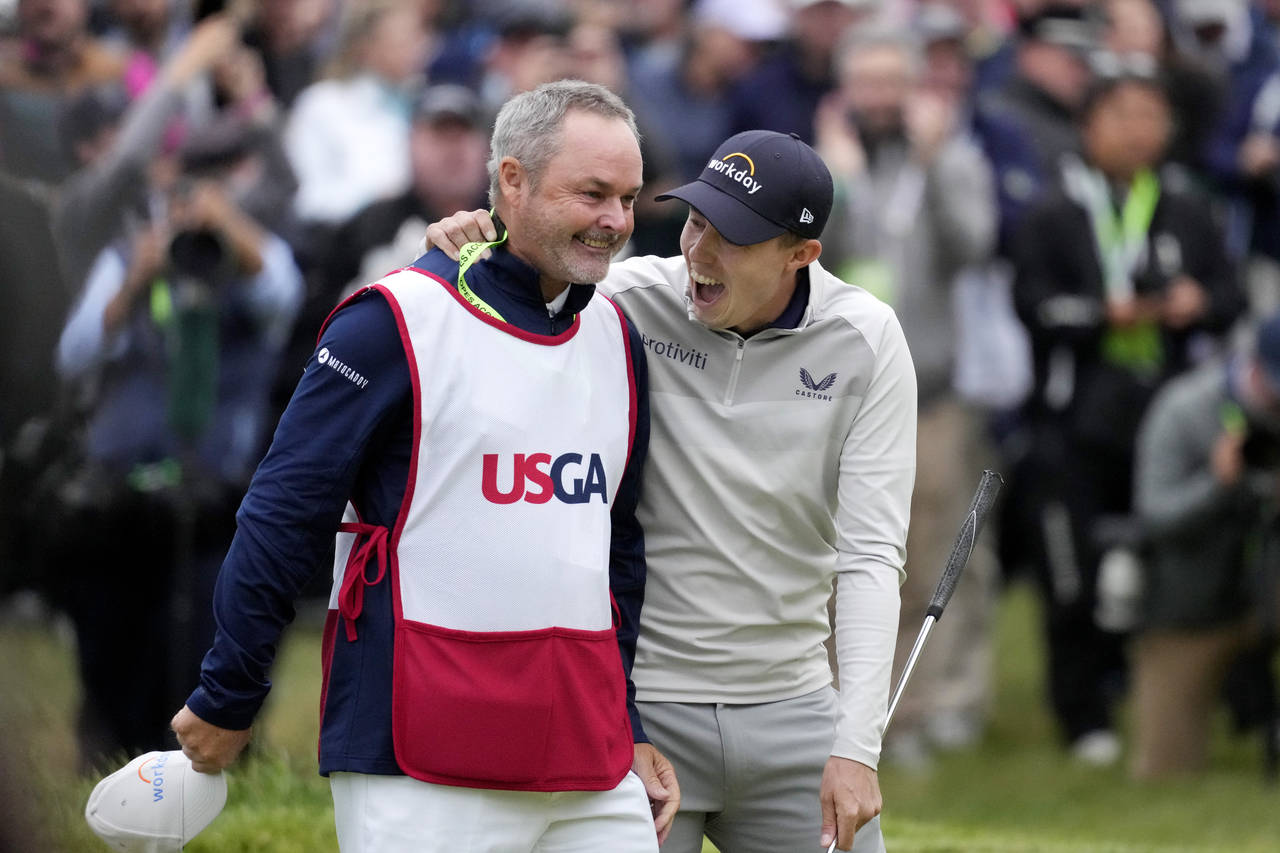 Matthew Fitzpatrick, of England, celebrates with his caddie after winning the U.S. Open golf tourna...