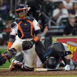 
              Miami Marlins' Miguel Rojas (11) is slow to get up after being hit by a pitch as Houston Astros catcher Martin Maldonado kneels behind home plate during the sixth inning of a baseball game Saturday, June 11, 2022, in Houston. (AP Photo/David J. Phillip)
            