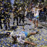 
              A man lays on Market Street as confetti rains during the Golden State Warriors NBA championship parade in San Francisco, Monday, June 20, 2022. (AP Photo/Eric Risberg)
            