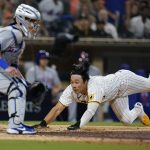 
              San Diego Padres' Ha-Seong Kim, right, slides home to score off an RBI-double by Nomar Mazara during the seventh inning of a baseball game against the New York Mets, Monday, June 6, 2022, in San Diego. (AP Photo/Gregory Bull)
            