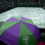 
              A rain cover is placed on the playing surface on day one of the Wimbledon tennis championships in London, Monday, June 27, 2022. (AP Photo/Alastair Grant)
            
