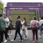 
              Spectators walk by a board showing the order of play on day one of the Wimbledon tennis championships in London, Monday, June 27, 2022. (AP Photo/Alberto Pezzali)
            