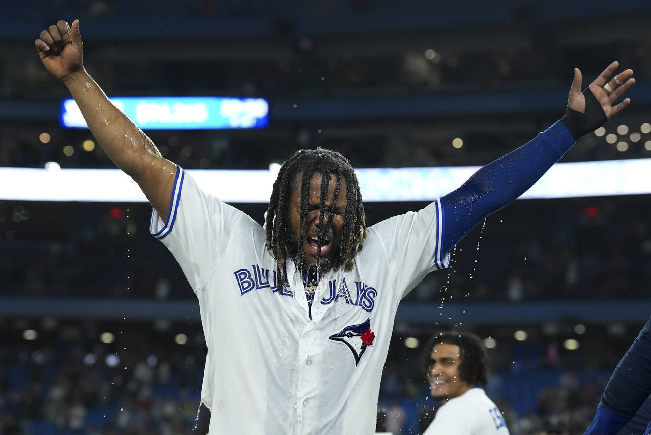 Toronto Blue Jays' Vladimir Guerrero Jr. raises his arms after being doused following the team's wi...