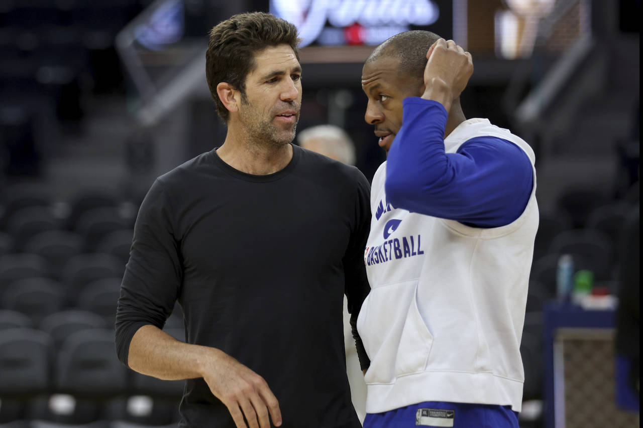 Golden State Warriors general manager Bob Myers, left, speaks with forward Andre Iguodala, right, d...