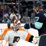 SEATTLE, WASHINGTON - DECEMBER 29: Martin Jones #35 of the Philadelphia Flyers watches the puck nearly deflected by Jaden Schwartz #17 of the Seattle Kraken during the second period at Climate Pledge Arena on December 29, 2021 in Seattle, Washington. (Photo by Steph Chambers/Getty Images)