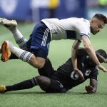 
              Vancouver Whitecaps' Marcus Godinho, top, and Minnesota United's Kemar Lawrence collide during the second half of an MLS soccer match Friday, July 8, 2022, in Vancouver, British Columbia. (Darryl Dyck/The Canadian Press via AP)
            