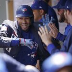 
              Toronto Blue Jays' George Springer wears the team's traditional home run jacket as he celebrates with teammates in the dugout after he hit a solo home run during the first inning of a baseball game against the Seattle Mariners, Sunday, July 10, 2022, in Seattle. (AP Photo/Ted S. Warren)
            