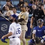 
              San Diego Padres' Trent Grisham, second from left, watches the ball go along with Los Angeles Dodgers starting pitcher Tony Gonsolin, left, catcher Austin Barnes, right, and home plate umpire Scott Barry after hitting a solo home run during the fifth inning of a baseball game Friday, July 1, 2022, in Los Angeles. (AP Photo/Mark J. Terrill)
            