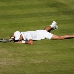 
              Serbia's Novak Djokovic lays on the court after falling making a return to Britain's Cameron Norrie in a men's singles semifinal on day twelve of the Wimbledon tennis championships in London, Friday, July 8, 2022. (AP Photo/Gerald Herbert)
            