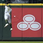 
              Oakland Athletics left fielder Tony Kemp leaps for but can't catch a triple by Seattle Mariners' Julio Rodriguez during the sixth inning of a baseball game, Friday, July 1, 2022, in Seattle. (AP Photo/Ted S. Warren)
            