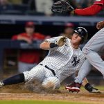 
              New York Yankees' DJ LeMahieu slides past Cincinnati Reds pitcher Alexis Diaz to score on a wild pitch during the 10th inning of a baseball game Wednesday, July 13, 2022, in New York. The Yankees won 7-6. (AP Photo/Frank Franklin II)
            