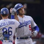 
              Los Angeles Dodgers' Freddie Freeman is congratulated by first base coach Clayton McCullough (86) after hitting a single during the first inning of a baseball game against the St. Louis Cardinals Thursday, July 14, 2022, in St. Louis. (AP Photo/Jeff Roberson)
            