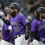 
              Colorado Rockies' Charlie Blackmon, front, is congratulated, after hitting a three-run home run, by Randal Grichuk, left, and Connor Joe during the sixth inning of the team's baseball game against the San Diego Padres on Tuesday, July 12, 2022, in Denver. (AP Photo/David Zalubowski)
            