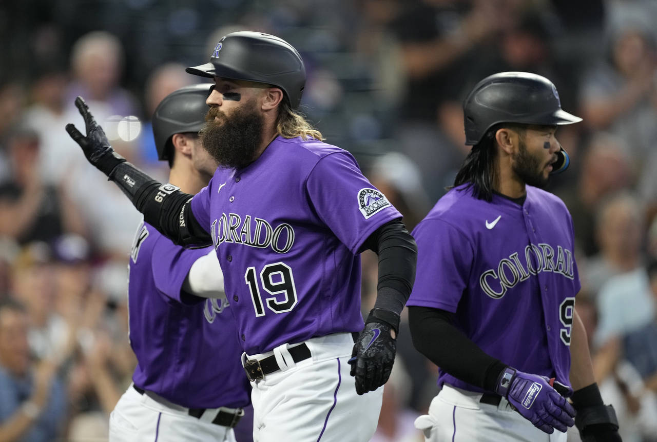 Colorado Rockies' Charlie Blackmon, front, is congratulated, after hitting a three-run home run, by...