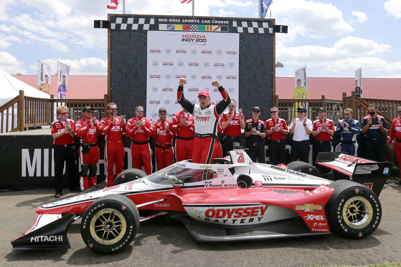 Scott McLaughlin, center, celebrates in Victory Circle after winning an IndyCar auto race at Mid-Oh...