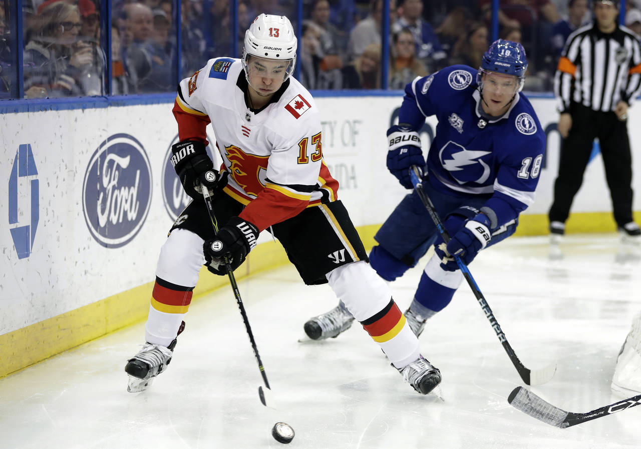 Calgary Flames left wing Johnny Gaudreau (13) carries the puck past Tampa Bay Lightning left wing O...