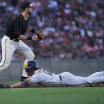 
              Milwaukee Brewers' Hunter Renfroe, bottom, slides into third base under San Francisco Giants third baseman Evan Longoria after hitting a double and advancing on a fielding error during the eighth inning of a baseball game in San Francisco, Saturday, July 16, 2022. (AP Photo/Jeff Chiu)
            