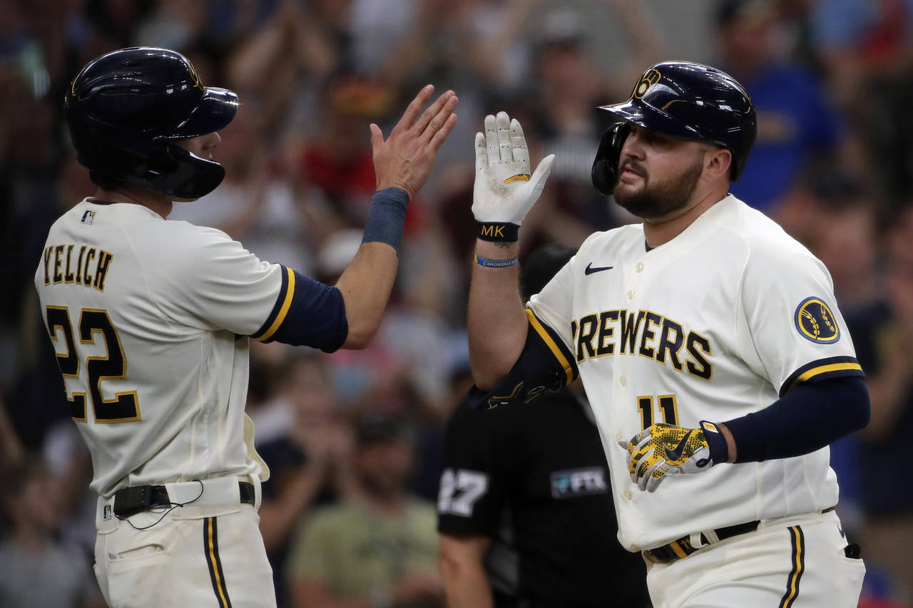 Milwaukee Brewers' Rowdy Tellez (11) is congratulated by Christian Yelich (22) after hitting a thre...