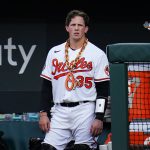 
              Baltimore Orioles' Adley Rutschman wears a chain in the dugout after hitting a solo home run off Los Angeles Angels starting pitcher Chase Silseth during the second inning of a baseball game, Thursday, July 7, 2022, in Baltimore. (AP Photo/Julio Cortez)
            