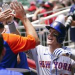 
              New York Mets' Mark Canha celebrates in the dugout after hitting a home run in the sixth inning of a baseball game against the Atlanta Braves Wednesday, July 13, 2022, in Atlanta. (AP Photo/John Bazemore)
            