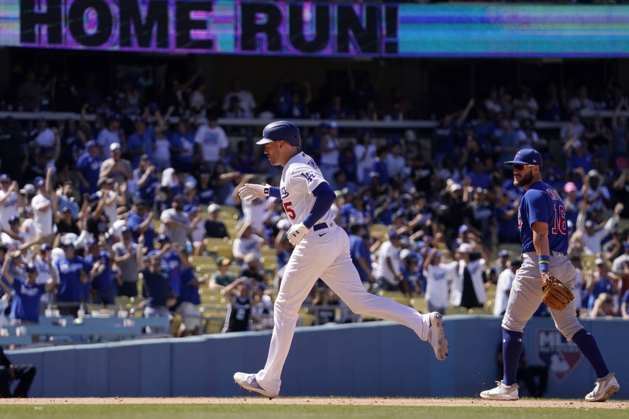 Los Angeles Dodgers' Freddie Freeman, left, rounds third after hitting a solo home run as Chicago C...