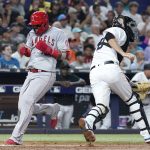 
              Los Angeles Angels' Jonathan Villar, left, scores past Miami Marlins catcher Jacob Stallings on a single by Shohei Ohtani during the fifth inning of a baseball game Wednesday, July 6, 2022, in Miami. (AP Photo/Lynne Sladky)
            