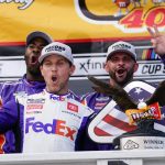 
              Denny Hamlin (11) celebrates with crew mates beside the trophy after winning the NASCAR Cup Series auto race at Pocono Raceway, Sunday, July 24, 2022, in Long Pond, Pa. (AP Photo/Matt Slocum)
            