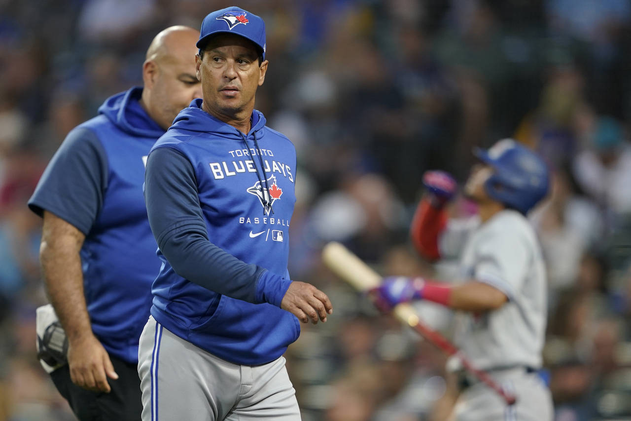 Toronto Blue Jays manager Charlie Montoyo walks with a trainer after Bradley Zimmer was hit by a pi...