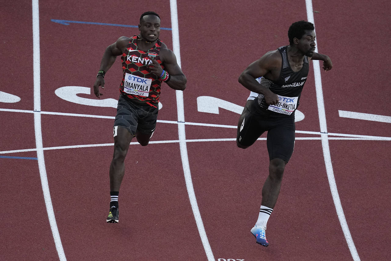 Ferdinand Omanyala, left, of Kenya, runs in a heat of the men's 100-meter run at the World Athletic...