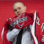 
              Ivan Miroshnichenko puts on a Washington Capitals jersey after beings selected during the first round of the NHL hockey draft in Montreal on Thursday, July 7, 2022. (Ryan Remiorz/The Canadian Press via AP)
            