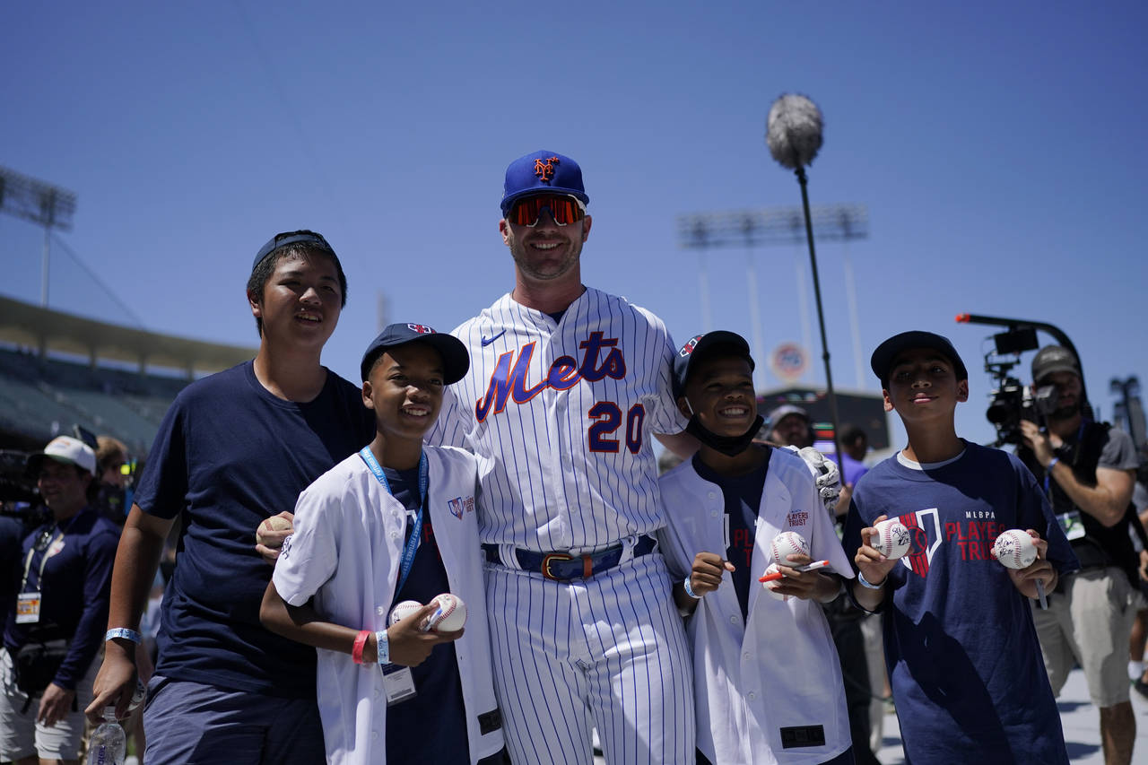 New York Mets' Pete Alonso takes photos with fans during batting practice a day before the 2022 MLB...