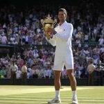 
              Serbia's Novak Djokovic holds the winners trophy as he celebrates after beating Australia's Nick Kyrgios to win the final of the men's singles on day fourteen of the Wimbledon tennis championships in London, Sunday, July 10, 2022. (AP Photo/Alastair Grant)
            