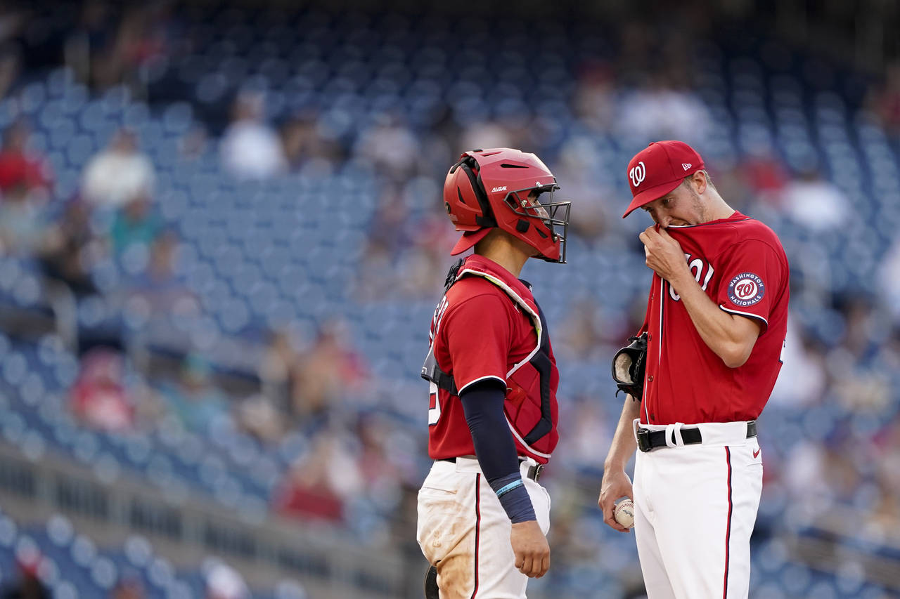 Washington Nationals starting pitcher Erick Fedde, right, visits with catcher Tres Barrera in the s...