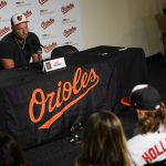 
              CORRECTS DATE -  Jackson Holliday, bottom right, the first overall draft pick by the Baltimore Orioles in the 2022 draft, looks on as his father and former major league player Matt Holliday, top, speaks during a news conference introducing Jackson to the Baltimore media prior to a baseball game between the Baltimore Orioles and the Tampa Bay Rays, Wednesday, July 27, 2022, in Baltimore. (AP Photo/Julio Cortez)
            
