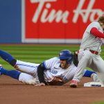
              Toronto Blue Jays' George Springer (4) steals second base next to Philadelphia Phillies second baseman Bryson Stott during the first inning of a baseball game Tuesday, July 12, 2022, in Toronto. (Christopher Katsarov/The Canadian Press via AP)
            