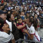 
              United States' Alex Morgan holds a child as she greats fans after defeating Jamaica 5-0 in a CONCACAF Women's Championship soccer match in Monterrey, Mexico, Thursday, July 7, 2022. (AP Photo/Fernando Llano)
            